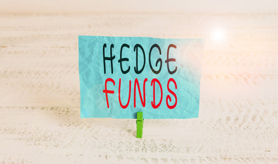 Word writing text Hedge Funds. Business photo showcasing basically a fancy name for an alternative investment partnership Green clothespin white wood background colored paper reminder office supply