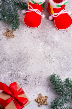 santa claus shoes, fir branches and gift box with red ribbons on a srone background, copz space, top view