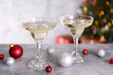 Beautiful christmas composition with two glasses of sparkling wine, decorations on textured table. New year's eve tradition to celebrate with champagne. Close up, copy space, background.