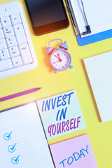 Writing note showing Invest In Yourself. Business concept for Improve your Skills take courses Do masters Scholarship White paper with copy space with paper clips clock and pc keyboard