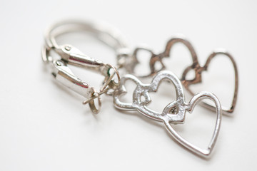Fototapeta na wymiar Three hearts in a line earrings. set of fashion earrings and decorations - Image