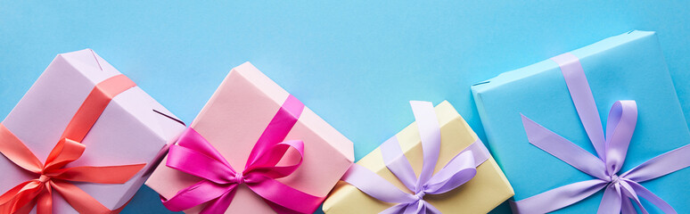 top view of colorful gift boxes on blue background, panoramic shot