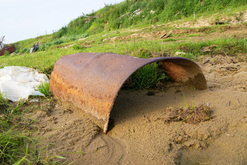 old rusty barrel lies on the shore in the sand