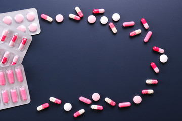Flat lay composition with bunch of different colorful pills in blister packs. Pile of unpacked...