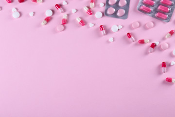 Flat lay composition with bunch of different colorful pills in blister packs. Pile of unpacked medication on paper textured background. Close up, copy space.