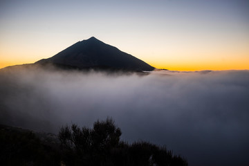 Sunset at the teide vulcan tenerife mountain with high clouds and top of the peak - orange sunlight...