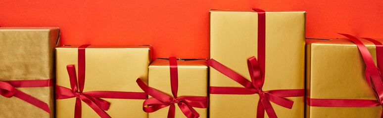 flat lay with golden gift boxes on red background, panoramic shot