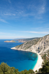 Bright scenic landscape view of Mediterranean Sea lapping at the white stone shore at Myrtos Beach,...