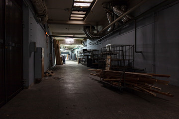 Naklejka na ściany i meble Long dark corridor in an old industrial building