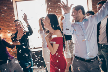 Photo of group friends on dance floor spending x-mas party together excited confetti air making birthday surprise wear formalwear red dress shirts indoors