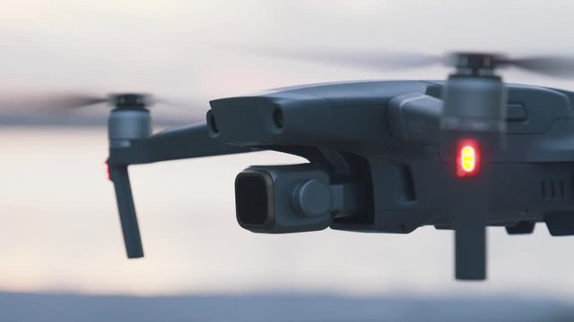 The drone is held in the air at sunset.