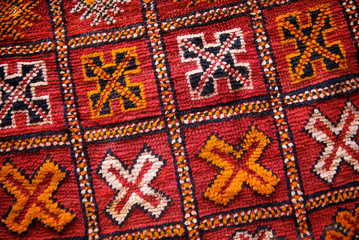 Full frame close up of the colorful textured patterns of an antique Morrocan rug in Marrakech, Morocco