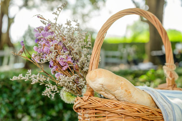 a basket of bread and flowers for outdoor picnic in garden