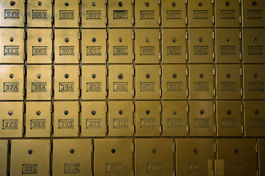 Wall of mailboxes with old brass grainy textured enamel doors