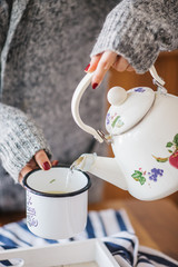a warm tea to heat a cold winter. The girl is holding herbal tea. a cup of linden tea