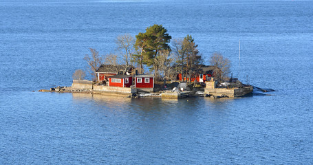 Small island with red houses in Stockholm archipelago in spring