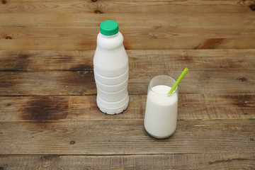 bottle of bio kefir and glass of kefir on the wooden rustic background with copy space for text. Dairy products.