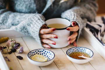 a warm tea to heat a cold winter. The girl is holding herbal tea. a cup of linden tea