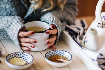 a warm tea to heat a cold winter. The girl is holding herbal tea. a cup of linden tea