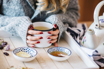 a warm tea to heat a cold winter. The girl is holding herbal tea. a cup of linden tea