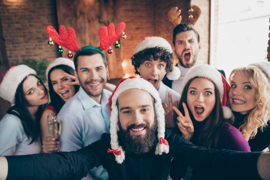 Photo of funky group meeting x-mas newyear party taking funny group selfies showing v-sign wear formalwear santa hats deer horns togetherness indoors