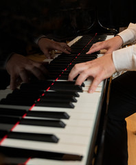Fototapeta na wymiar Pianista suona sul pianoforte con le mani in posizione sui tasti della tastiera, bellissimo