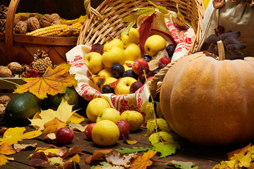 Fruits and vegetables with pumpkins, apples, corn, nuts, mushrooms, berries - autumn harvest and healthy food concept. Yellow leaves. Still life on wooden background.