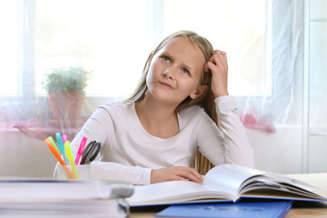 Blondes Mädchen liest ein Buch und überlegt