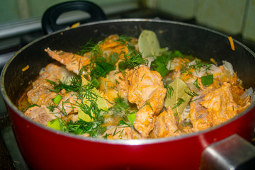 Meat with onions, carrots, dill and Bay leaf is stewed in a saucepan. Home cooking.