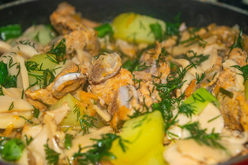 Meat with onions, carrots, potatoes, dill and Bay leaf is stewed in a saucepan. Home cooking. Close up.