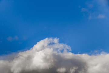 Beautiful white clouds on a background of blue sky. Defocused image for design.