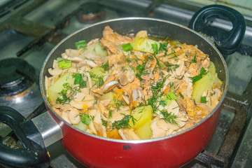 Meat with onions, carrots, potatoes, dill and Bay leaf is stewed in a saucepan. Home cooking.