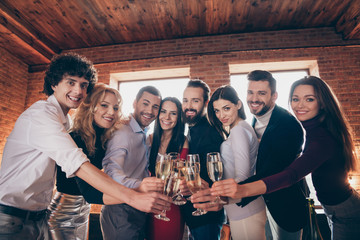 Portrait of nice attractive elegant cheerful cheery friendly people celebrating festive festal day meeting clinking glass greeting at modern industrial loft brick wood style interior lights house