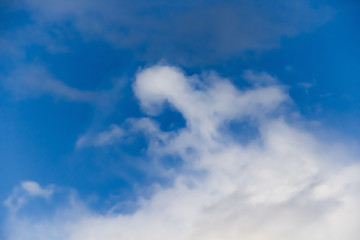 Beautiful white clouds on a background of blue sky. Defocused image for design.