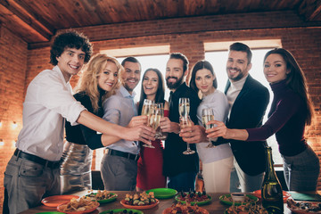 Portrait of nice attractive elegant cheerful cheery glad people celebrating birthday meeting clinking glass congratulation celebratory at modern industrial loft brick wood style interior lights house
