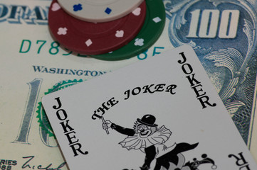 Gambling concept poker cards royal flush, four aces, joker on bank notes and casino chips.  Selective focus. 