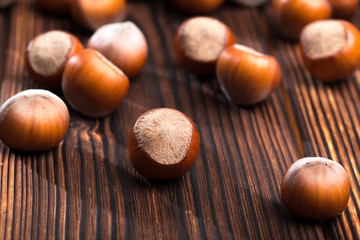 close up of hazelnuts on wooden table .