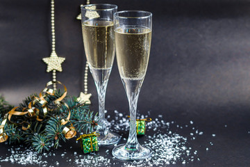 Christmas mood. Glasses with champagne. New Year. Christmas-tree decorations, coniferous branches. Copy space. 