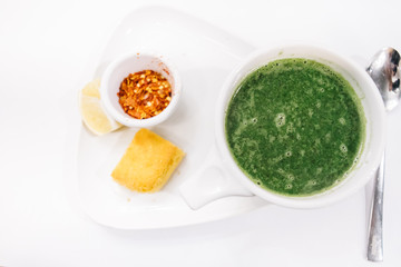 Turkish traditional nettle soup on wooden and white background.Soup with fresh nettles