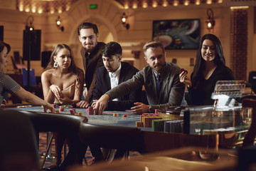 Friends gambling betting in a casino.