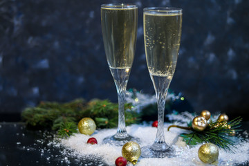 Christmas mood. Glasses with champagne. New Year. Christmas-tree decorations, coniferous branches. Copy space. 