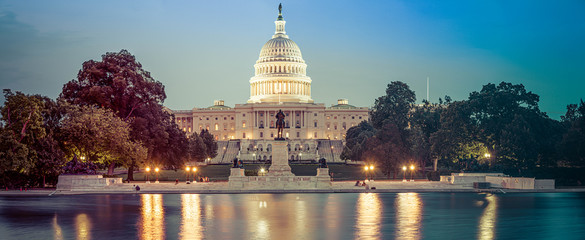 Panorama of the Capitol of the Unites States in evening light with the Capitol Reflecting Pool in the foreground.