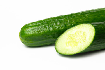 Ripe green long cucumber in a cut on a white background