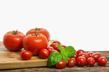 TOMATOES ON A BOARD WITH BASIL AND SPICES