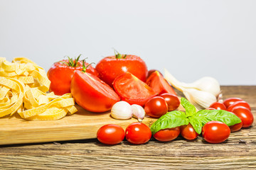 TOMATOES ON A BOARD WITH BASIL AND SPICES
