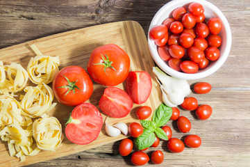 TOMATOES ON A BOARD WITH BASIL AND SPICES