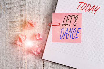 Writing note showing Let S Is Dance. Business concept for move rhythmically to music following a set sequence of steps Notebook stationary placed above classic wooden backdrop