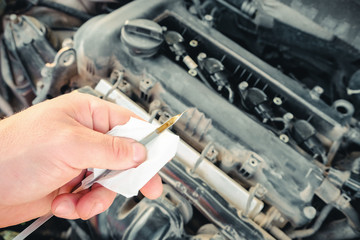 checking the oil level in a car engine