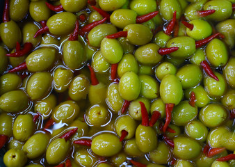olives with hot red paper, chilli, picking from plants during harvesting, green - 301395212
