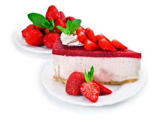 Piece of cheesecake with fresh strawberries and mint isolated on a white background